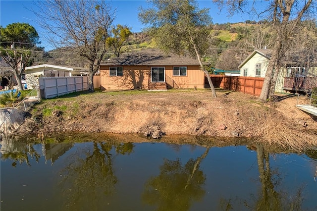 back of property featuring a water view