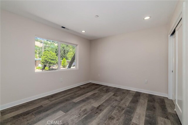 unfurnished bedroom with a closet and dark hardwood / wood-style floors