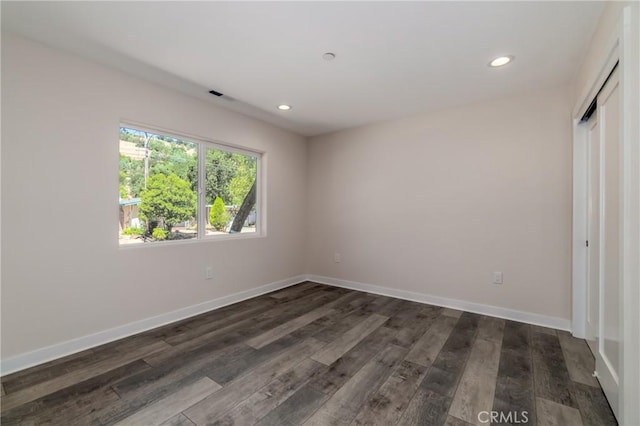 unfurnished bedroom with a closet and dark hardwood / wood-style floors