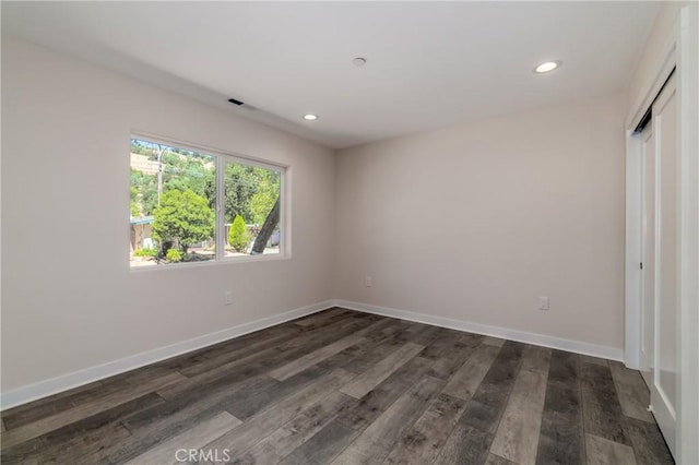 unfurnished bedroom with dark wood-style floors, baseboards, a closet, and recessed lighting