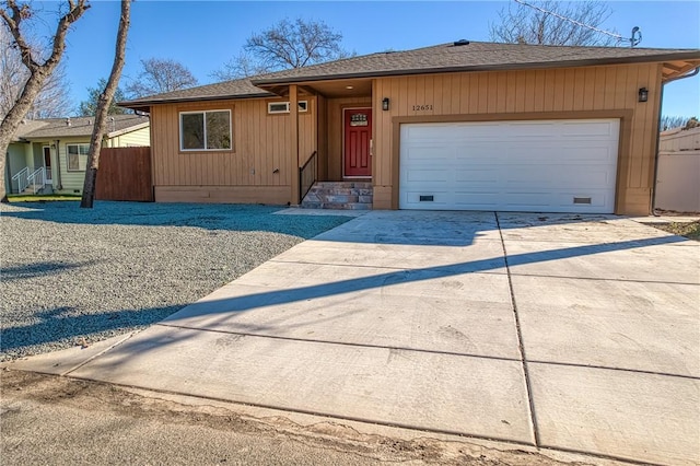 view of front of house with a garage, a shingled roof, concrete driveway, crawl space, and fence