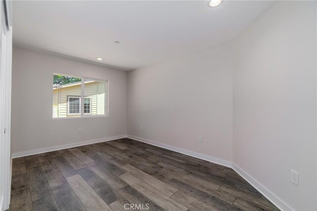 spare room with recessed lighting, dark wood-style flooring, and baseboards