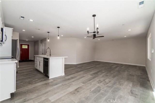 kitchen with black dishwasher, an island with sink, decorative light fixtures, and white cabinetry