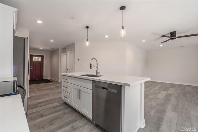 kitchen featuring sink, white cabinets, dishwasher, an island with sink, and pendant lighting