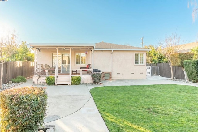 rear view of house featuring a yard and a patio area