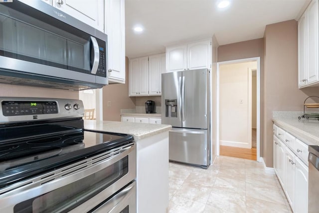 kitchen featuring white cabinets, stainless steel appliances, and light tile patterned flooring