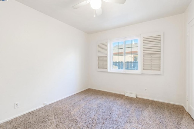 spare room with ceiling fan and carpet