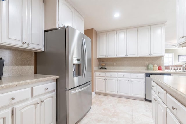 kitchen featuring stainless steel appliances, white cabinets, light tile patterned flooring, and tasteful backsplash