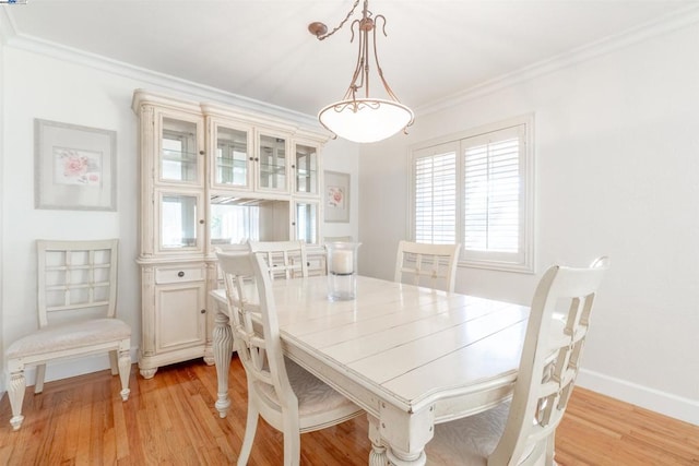 dining area with light wood-type flooring and crown molding