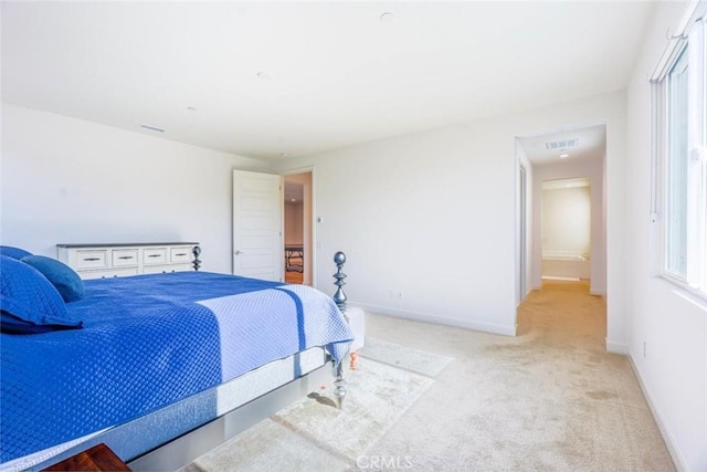 bedroom with baseboards, light colored carpet, and visible vents