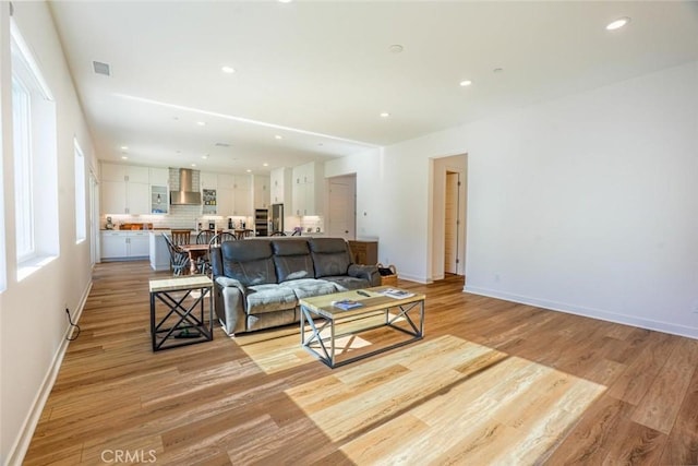 living room with baseboards, recessed lighting, light wood finished floors, and visible vents