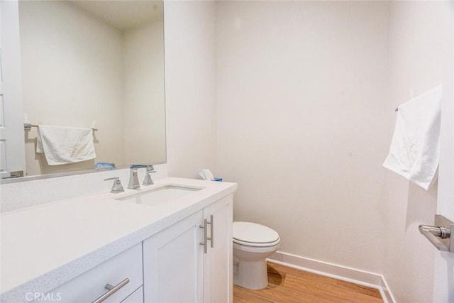 bathroom featuring hardwood / wood-style flooring, toilet, and vanity