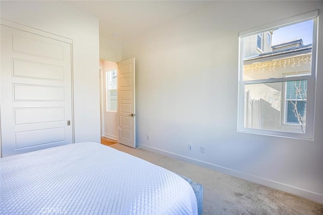 bedroom featuring baseboards and light colored carpet