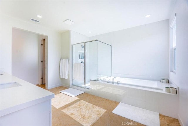 full bathroom with plenty of natural light, a stall shower, a garden tub, and visible vents