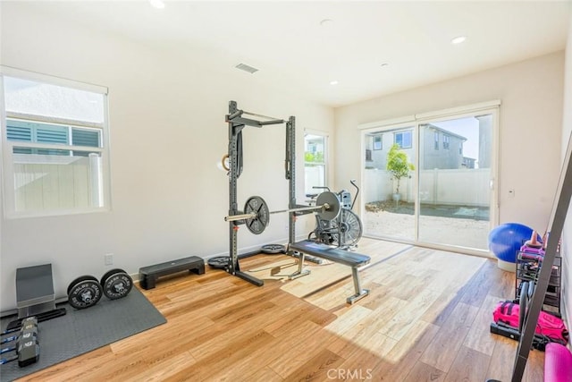 exercise area featuring recessed lighting, visible vents, and wood finished floors