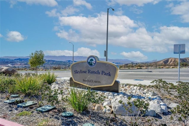 community / neighborhood sign with a mountain view