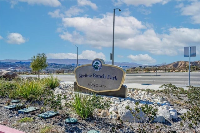 community / neighborhood sign with a mountain view
