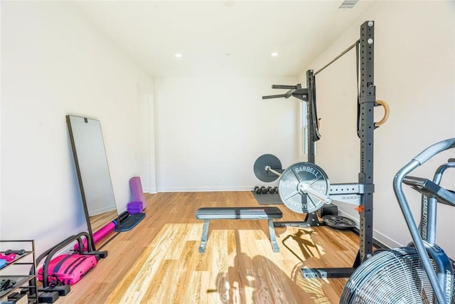 exercise area featuring recessed lighting, baseboards, and wood finished floors