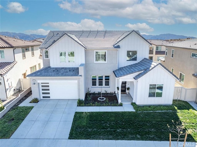 modern farmhouse featuring a garage, a mountain view, and a front lawn