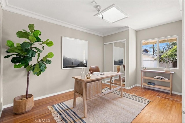 office space with crown molding, baseboards, and wood finished floors