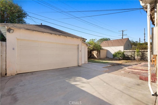 detached garage featuring fence