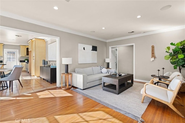 living room featuring light hardwood / wood-style floors and ornamental molding