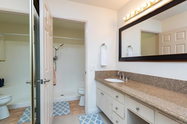 bathroom with toilet, tile patterned flooring, and vanity