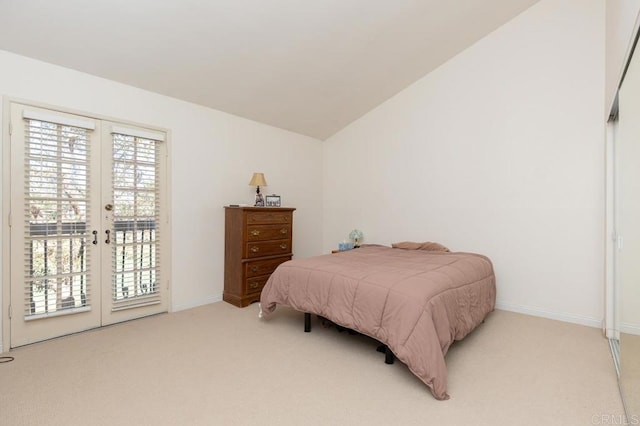 carpeted bedroom with access to outside, french doors, and lofted ceiling