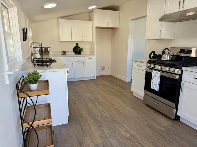 kitchen with gas range, light stone counters, dark hardwood / wood-style floors, white cabinetry, and lofted ceiling