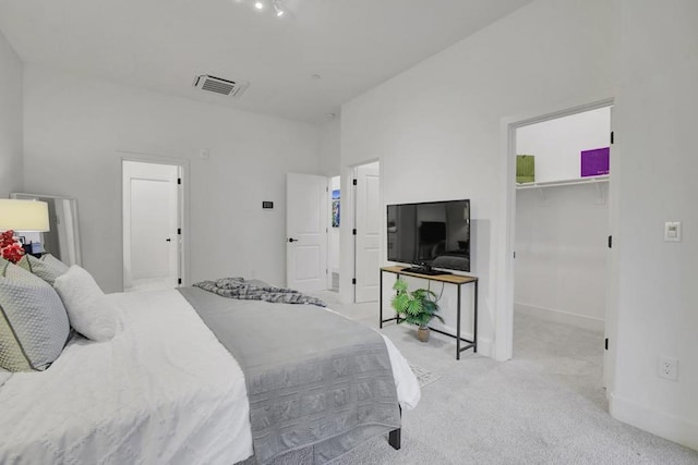 carpeted bedroom featuring a spacious closet and a closet