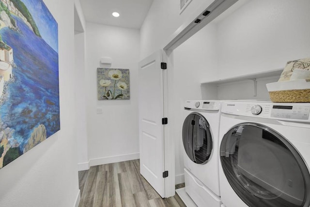 washroom with light wood-type flooring and washing machine and dryer