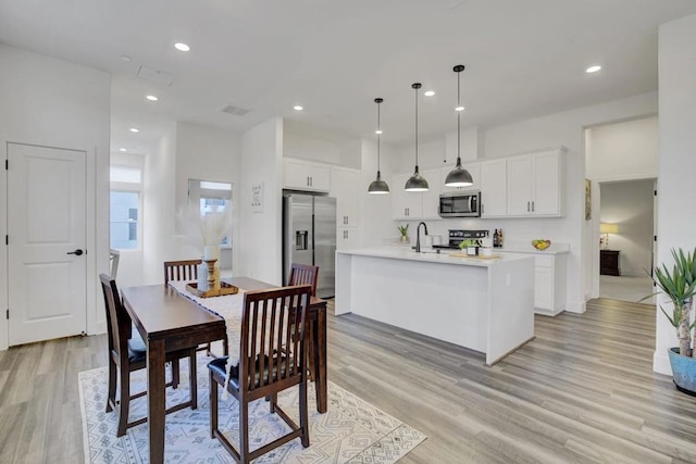 dining area featuring sink and light hardwood / wood-style floors