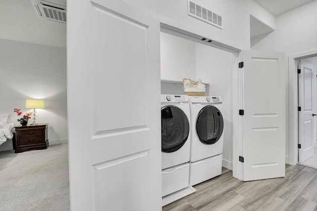 laundry area with light carpet and washing machine and clothes dryer