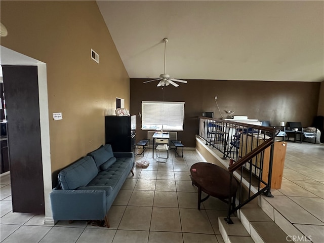 tiled living room with ceiling fan and high vaulted ceiling