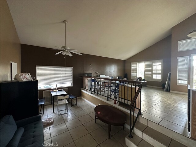 tiled living room featuring ceiling fan and vaulted ceiling