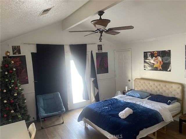 bedroom featuring ceiling fan, lofted ceiling, wood-type flooring, and a textured ceiling