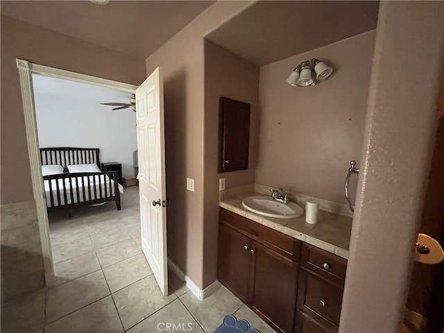 bathroom with ceiling fan, baseboards, tile patterned flooring, and vanity
