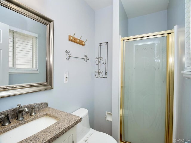 bathroom featuring toilet, an enclosed shower, and vanity