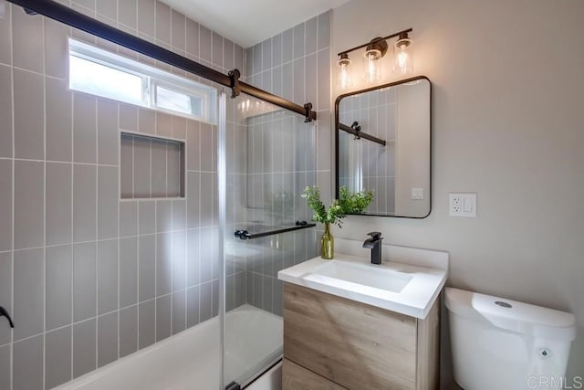 full bathroom with vanity, shower / bath combination with glass door, and toilet