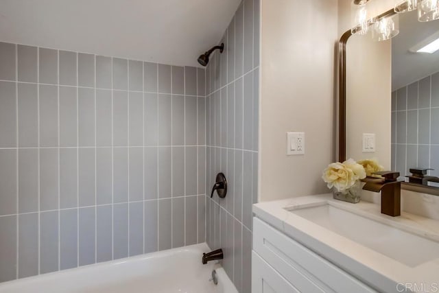 bathroom featuring tiled shower / bath and vanity