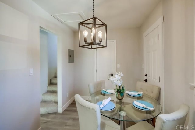 dining space featuring wood-type flooring, electric panel, and a chandelier