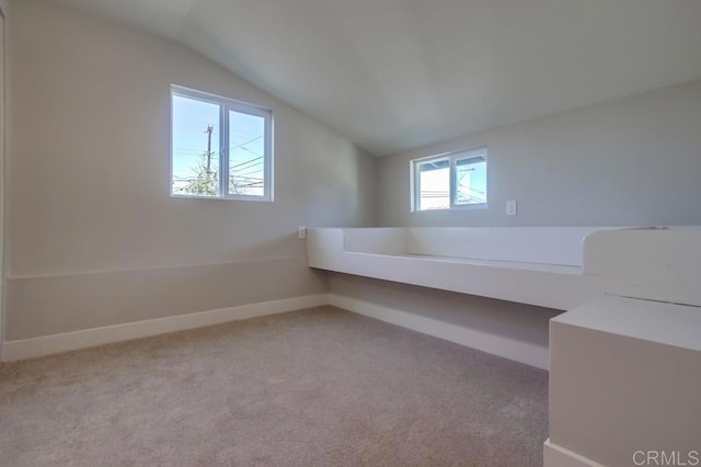 additional living space with vaulted ceiling and light carpet