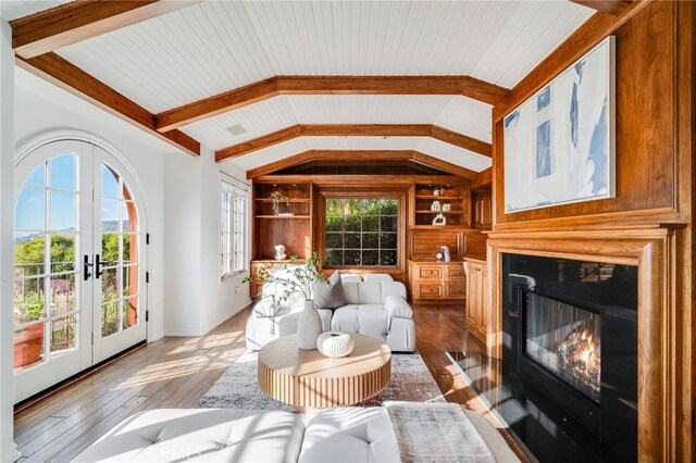 living room with built in shelves, lofted ceiling with beams, french doors, and wooden ceiling