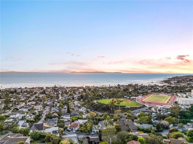 aerial view at dusk featuring a water view