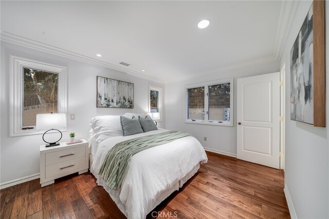 bedroom featuring multiple windows, ornamental molding, and hardwood / wood-style floors