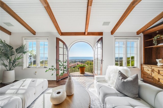 living room with wood-type flooring, beam ceiling, and french doors