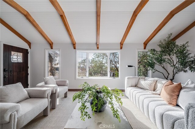 living room with vaulted ceiling with beams and light colored carpet