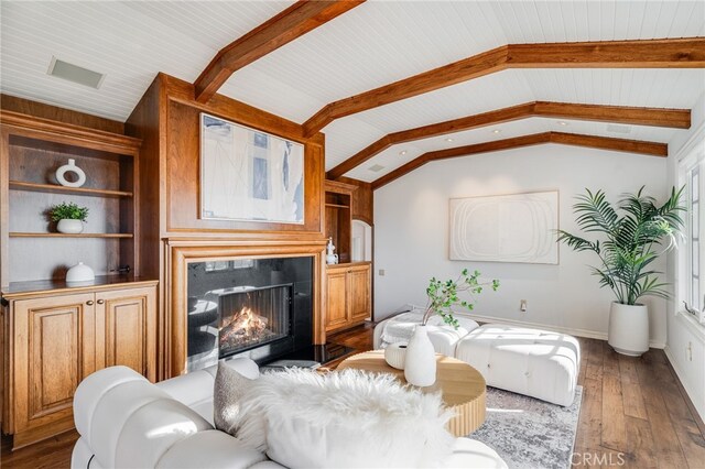 living room with vaulted ceiling with beams, dark wood-type flooring, built in features, and a premium fireplace