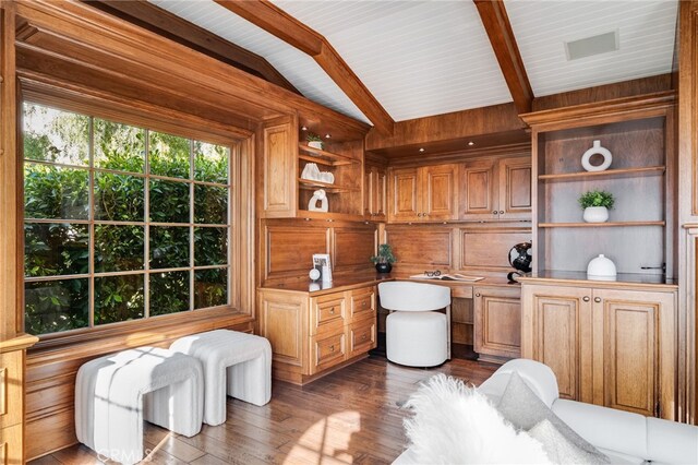 office space featuring lofted ceiling with beams, dark hardwood / wood-style flooring, and wood walls