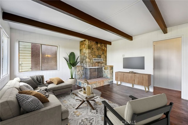 living room with a stone fireplace, beamed ceiling, and hardwood / wood-style flooring